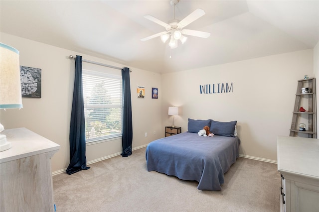 bedroom featuring light colored carpet, baseboards, lofted ceiling, and ceiling fan