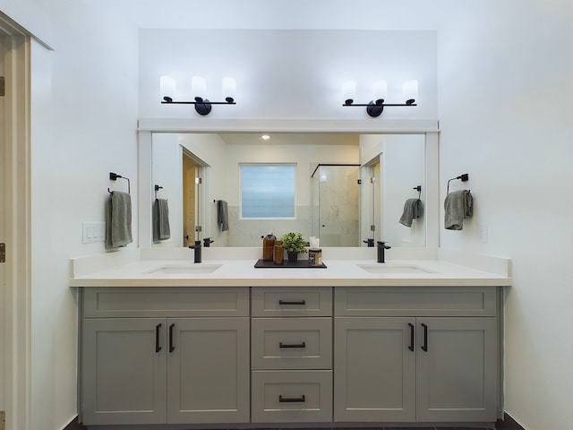 bathroom featuring a sink, a marble finish shower, and double vanity