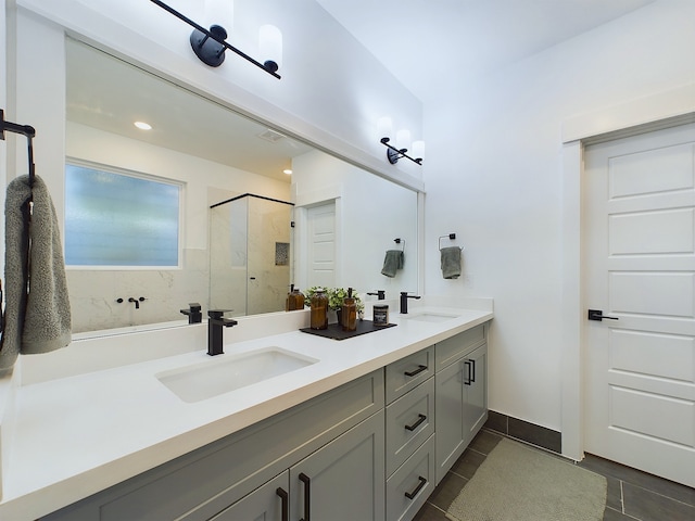 bathroom featuring a sink, double vanity, a shower stall, and tile patterned flooring