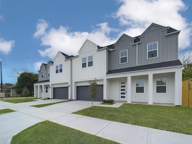 view of front of home with driveway, a front lawn, board and batten siding, and an attached garage