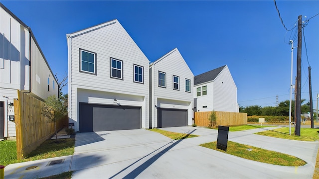 view of front of property featuring an attached garage, driveway, and fence