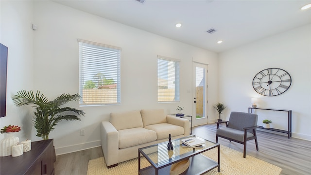 living area featuring light wood-type flooring, visible vents, a healthy amount of sunlight, and recessed lighting