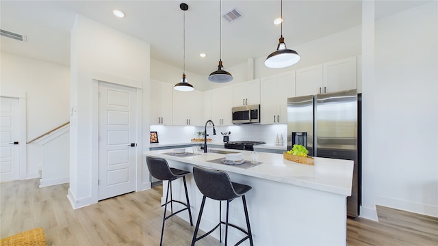 kitchen featuring tasteful backsplash, visible vents, light wood-style flooring, and appliances with stainless steel finishes