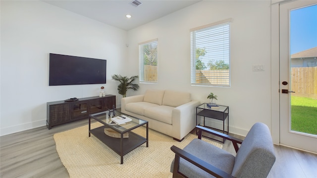 living room with recessed lighting, visible vents, baseboards, and light wood finished floors