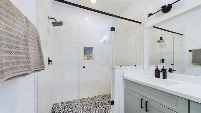 full bath with a marble finish shower and vanity