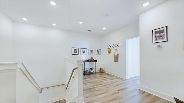 interior space featuring an upstairs landing, recessed lighting, baseboards, and light wood-style floors