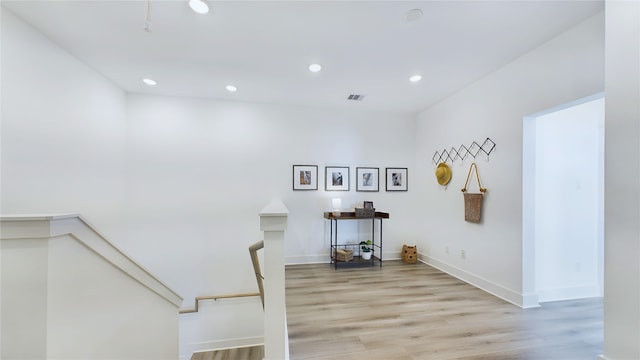 interior space with an upstairs landing, visible vents, recessed lighting, and light wood-type flooring