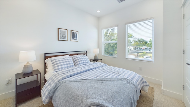 bedroom featuring recessed lighting, light colored carpet, visible vents, and baseboards