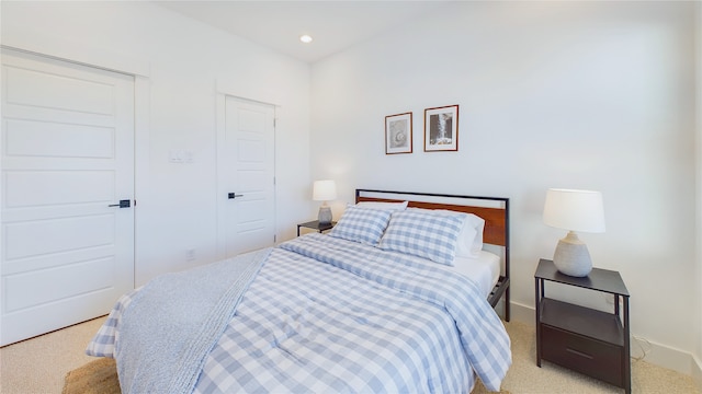 bedroom featuring baseboards, recessed lighting, a closet, and light carpet