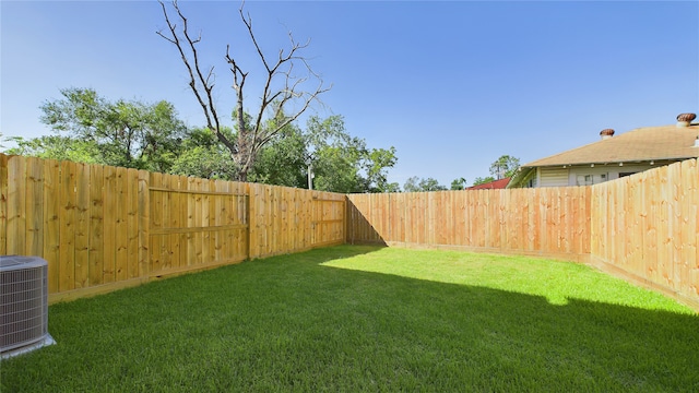 view of yard featuring central AC and a fenced backyard