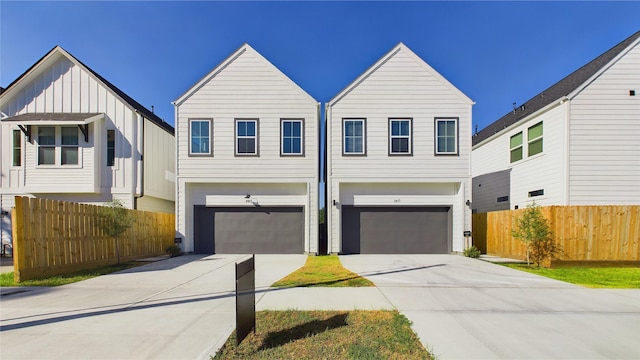 view of front facade featuring an attached garage, fence, and driveway