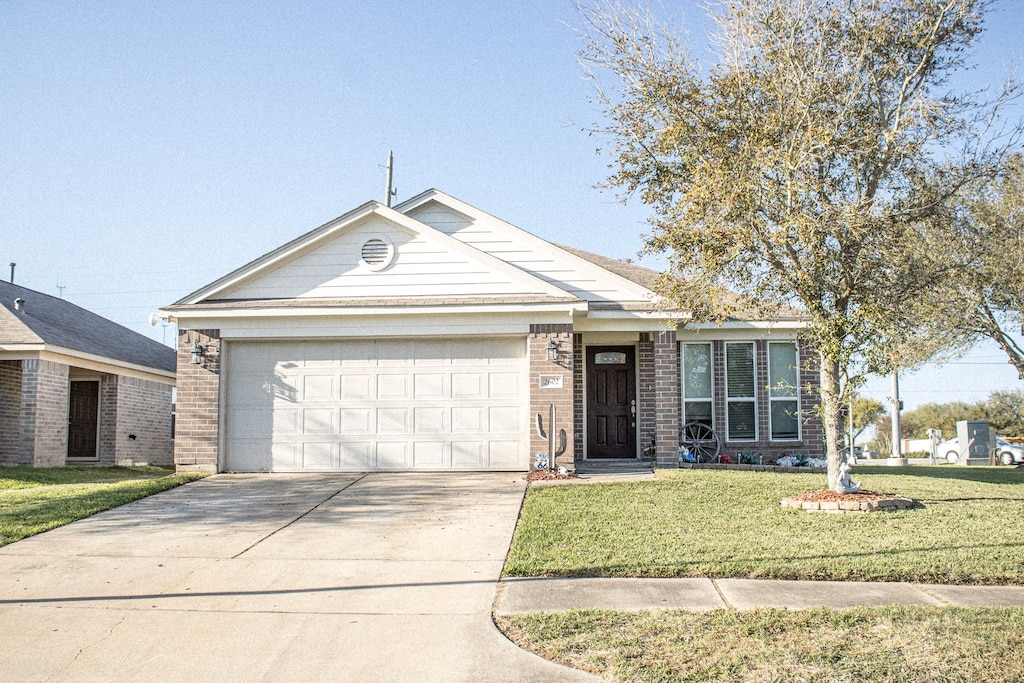 ranch-style house featuring a garage, driveway, brick siding, and a front yard