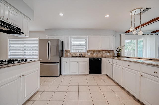 kitchen featuring plenty of natural light, a sink, black appliances, under cabinet range hood, and tasteful backsplash