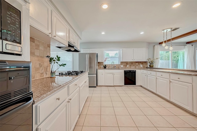 kitchen with tasteful backsplash, under cabinet range hood, white cabinets, stainless steel appliances, and a sink