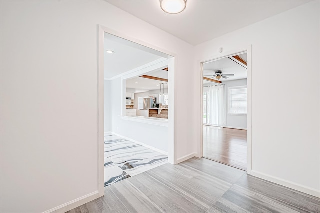 corridor with wood finished floors and baseboards