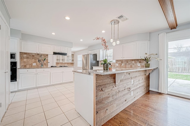 kitchen featuring visible vents, white cabinets, appliances with stainless steel finishes, and a peninsula