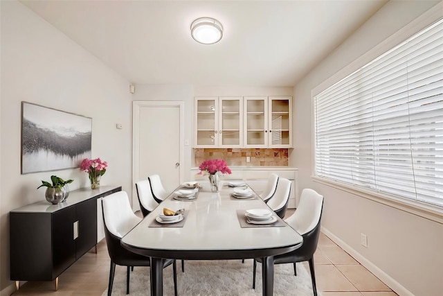 dining space featuring light tile patterned floors and baseboards