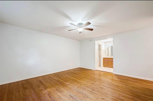 empty room featuring visible vents, light wood-style flooring, a ceiling fan, and baseboards