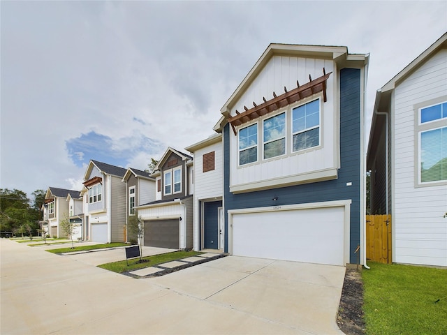 view of property with concrete driveway, a garage, board and batten siding, and a residential view