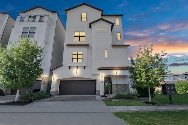 view of front of house with stucco siding, driveway, and an attached garage