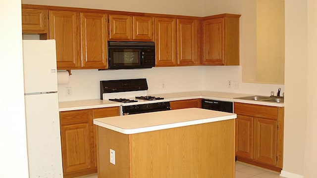 kitchen featuring brown cabinetry, a sink, black appliances, light countertops, and a center island