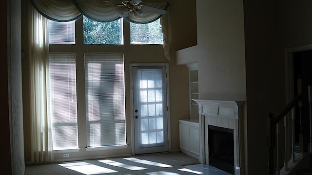 doorway to outside featuring a ceiling fan and a tile fireplace