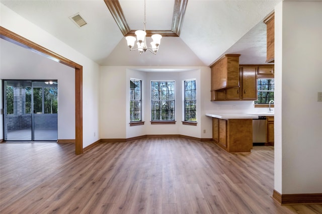 kitchen with brown cabinetry, visible vents, light countertops, dishwasher, and open floor plan