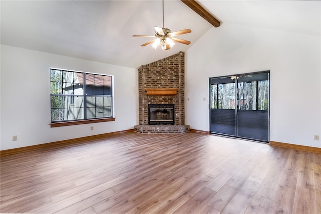 unfurnished living room featuring wood finished floors, baseboards, high vaulted ceiling, a fireplace, and beamed ceiling