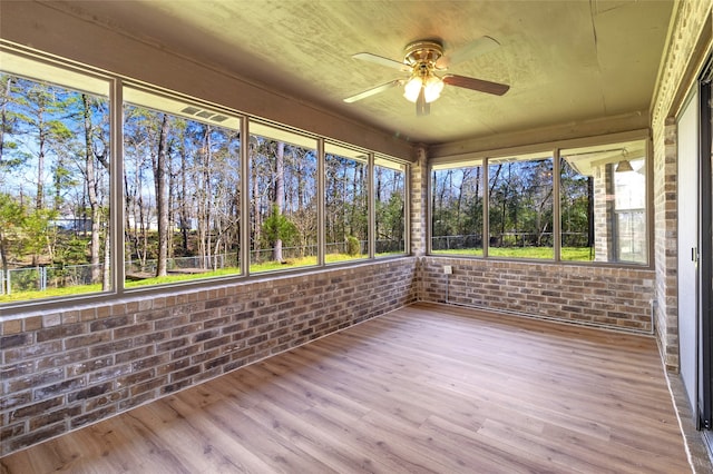 unfurnished sunroom featuring a wealth of natural light and ceiling fan