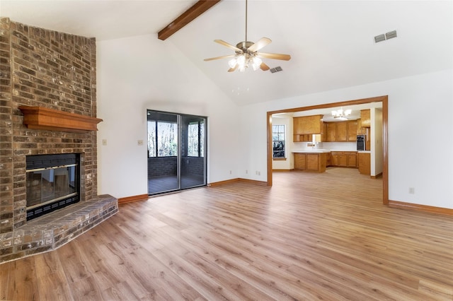 unfurnished living room featuring light wood-type flooring, visible vents, high vaulted ceiling, beamed ceiling, and a fireplace