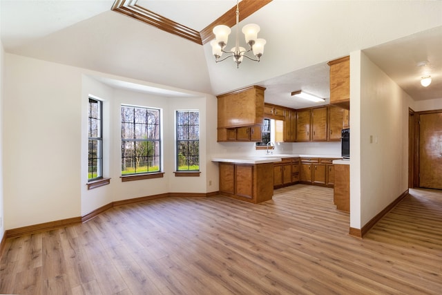 kitchen with light wood finished floors, oven, light countertops, brown cabinets, and a sink