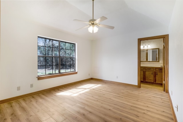 unfurnished bedroom featuring light wood finished floors, connected bathroom, baseboards, and lofted ceiling