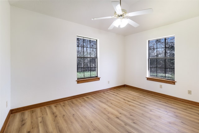 empty room featuring baseboards, plenty of natural light, a ceiling fan, and light wood finished floors