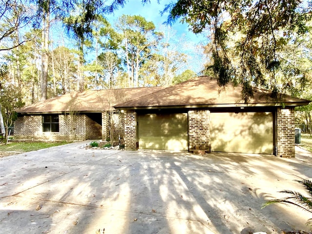 view of front of house featuring concrete driveway, a garage, and brick siding