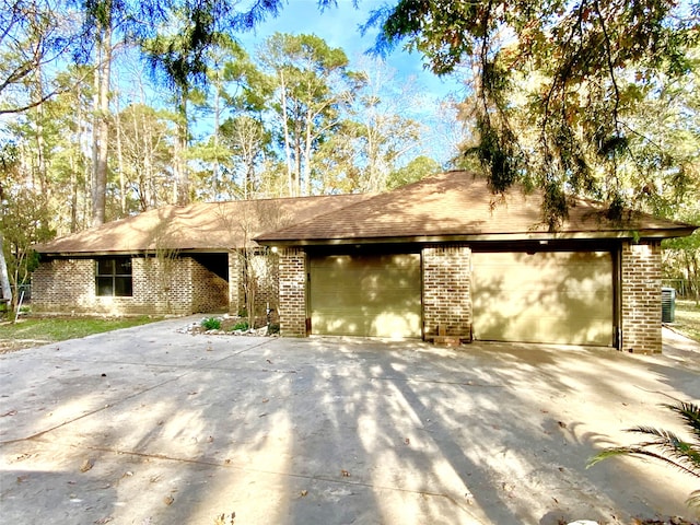 view of front of property with brick siding, driveway, and a garage