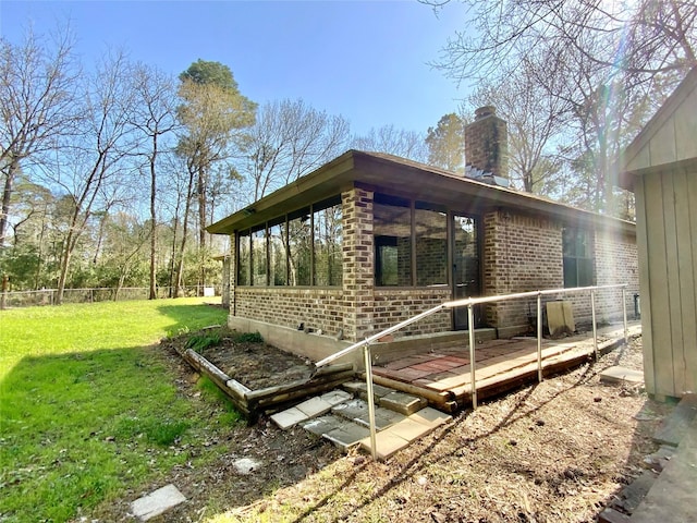 deck featuring a yard, fence, and a sunroom