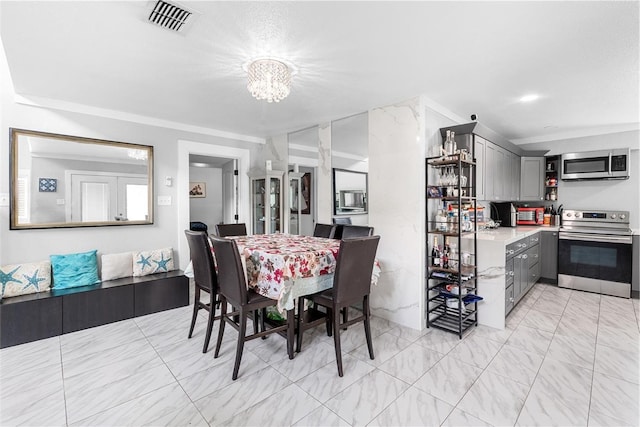 dining room with a notable chandelier, visible vents, and marble finish floor