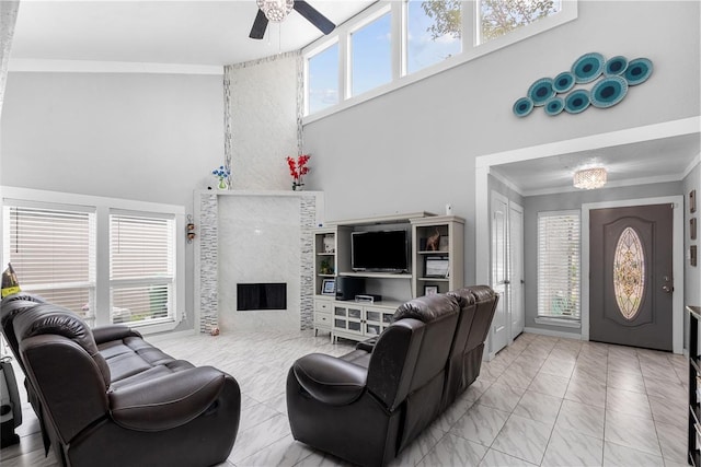 living area with plenty of natural light, marble finish floor, a fireplace, and crown molding