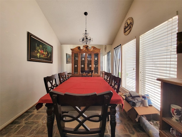 dining room with lofted ceiling, a notable chandelier, baseboards, and a textured ceiling