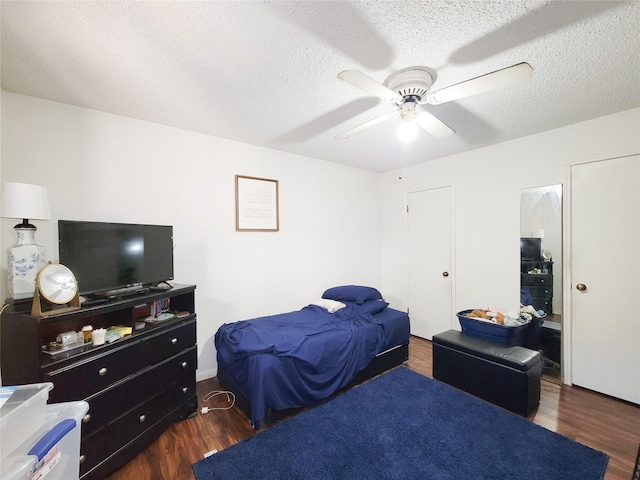 bedroom with a textured ceiling, wood finished floors, and a ceiling fan