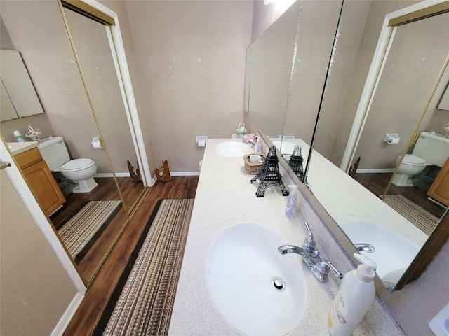 full bath featuring a sink, baseboards, toilet, and wood finished floors