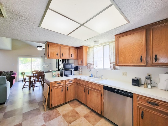 kitchen featuring brown cabinets, stainless steel appliances, light countertops, and a sink