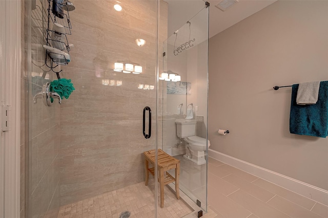 bathroom featuring visible vents, a shower stall, toilet, and baseboards