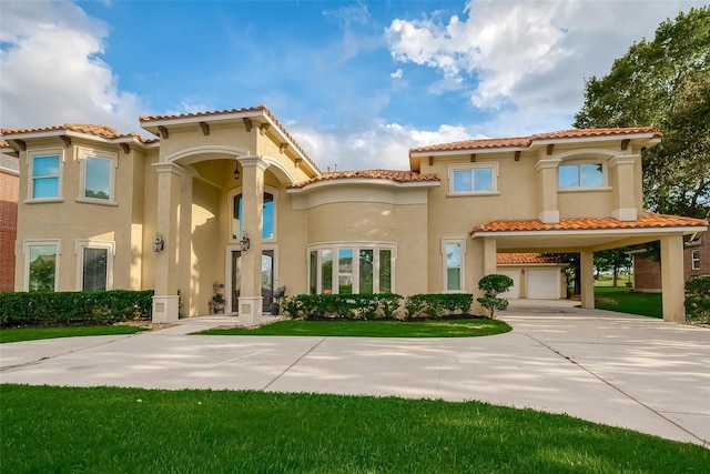 mediterranean / spanish-style house featuring an attached garage, a tiled roof, a front yard, stucco siding, and driveway