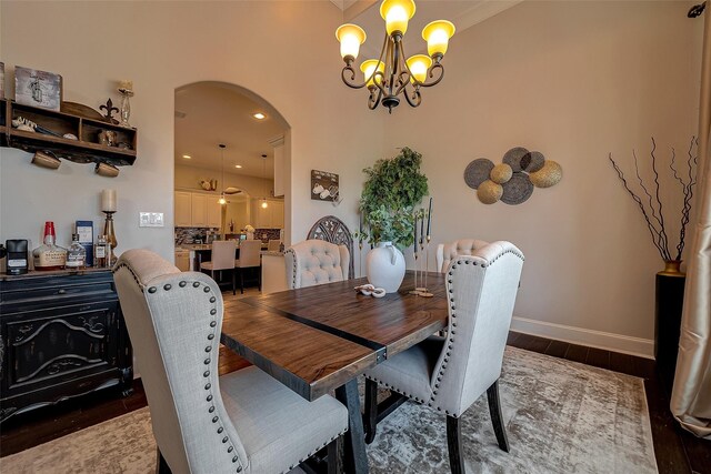 dining area featuring baseboards, recessed lighting, wood finished floors, arched walkways, and a notable chandelier