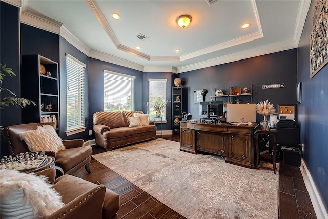 office space featuring a tray ceiling, visible vents, baseboards, and wood finished floors