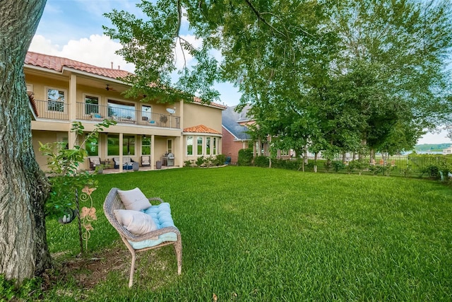 view of yard with a patio, a balcony, and fence