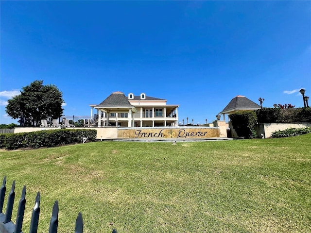 back of house with a lawn and fence