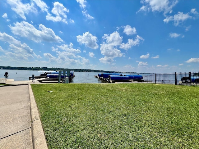 exterior space featuring fence, a dock, and a water view