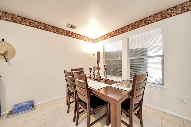 dining room featuring light tile patterned floors, visible vents, and baseboards